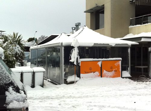 Parasol Umbrella withstanding the weight of a recent snow fall at a restaurant