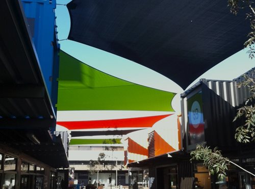Large Shade Sails hanging over a public area surrounded by shops