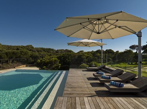 Cantilever Umbrella provding shade for lounging areas beside a pool